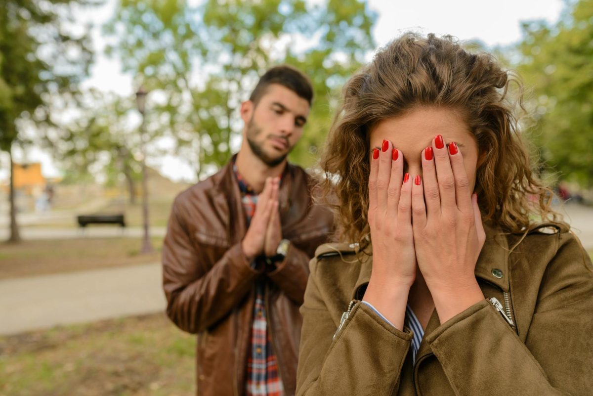 woman with green jacket behind man with brown leather jacket at daytime