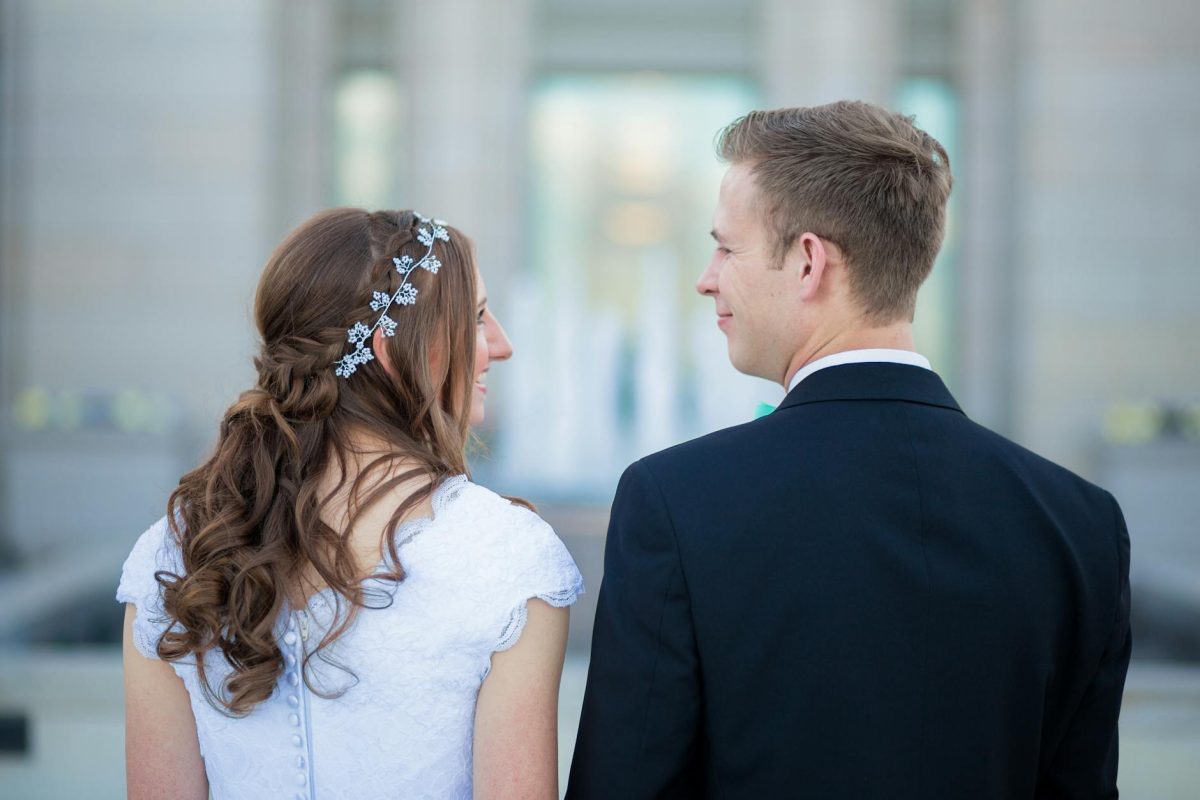 man standing beside woman wearing white cap sleeved dress